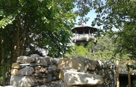 Gartenschule Langenlois Aussichtsturm, © Roman Zöchlinger Aussichtsturm der Gartenschule Langenlois umgeben von Bäumen und einer Steinmauer.