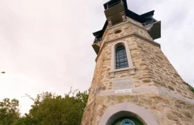 Kamptalwarte am Heidenreichstein, © Matthias Schickhofer Steinerner Aussichtsturm mit Fenstern und Inschrift, umgeben von Bäumen.