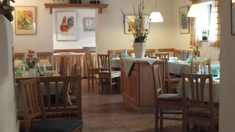 Cobaneshof, © Cobaneshof Gemütliches Restaurant mit Holzmöbeln, gedeckten Tischen und Blumenvasen. Bilder von Tieren an den Wänden.