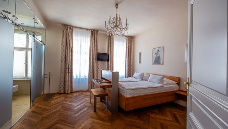 vierzigerhof, © Niederösterreich Werbung / Maximilian Pawlikowsky Elegantes Hotelzimmer mit Doppelbett, Parkettboden und Kronleuchter.