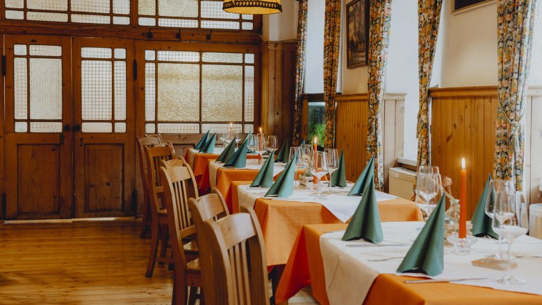 Einkehren und Platz nehmen, © Niederösterreich Werbung/Rita Newman Ein Koch in schwarzer Uniform kocht in einer professionellen Küche mit mehreren Töpfen und Kellen an der Wand.