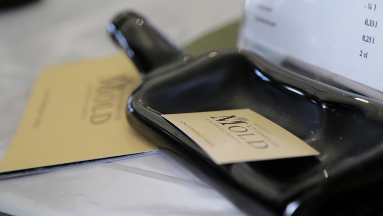 Weingut Erwin & Christa Fichtenbauer-Mold, © Waldviertel Tourismus_Theresia Steinkellner Stand Nahaufnahme eines schwarzen Keramikgefäßes mit einer Visitenkarte des Weinguts Mold darauf.