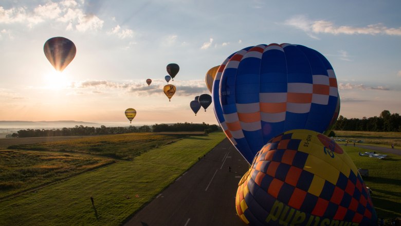 Hei&szlig;luftballons starten bei Sonnenaufgang vom Flughafen Krems-Gneixendorf.