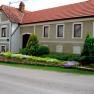 Traditionelles Bauernhaus mit gepflegtem Garten und roten Ziegeld&auml;chern.