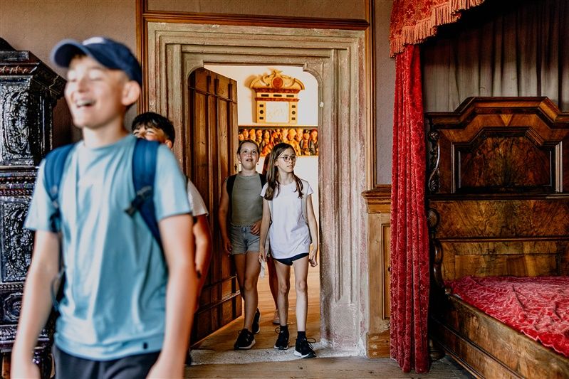Kinder betreten einen Raum in einem Renaissanceschloss.