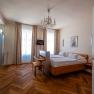 Elegantes Hotelzimmer mit Doppelbett, Parkettboden und Kronleuchter.