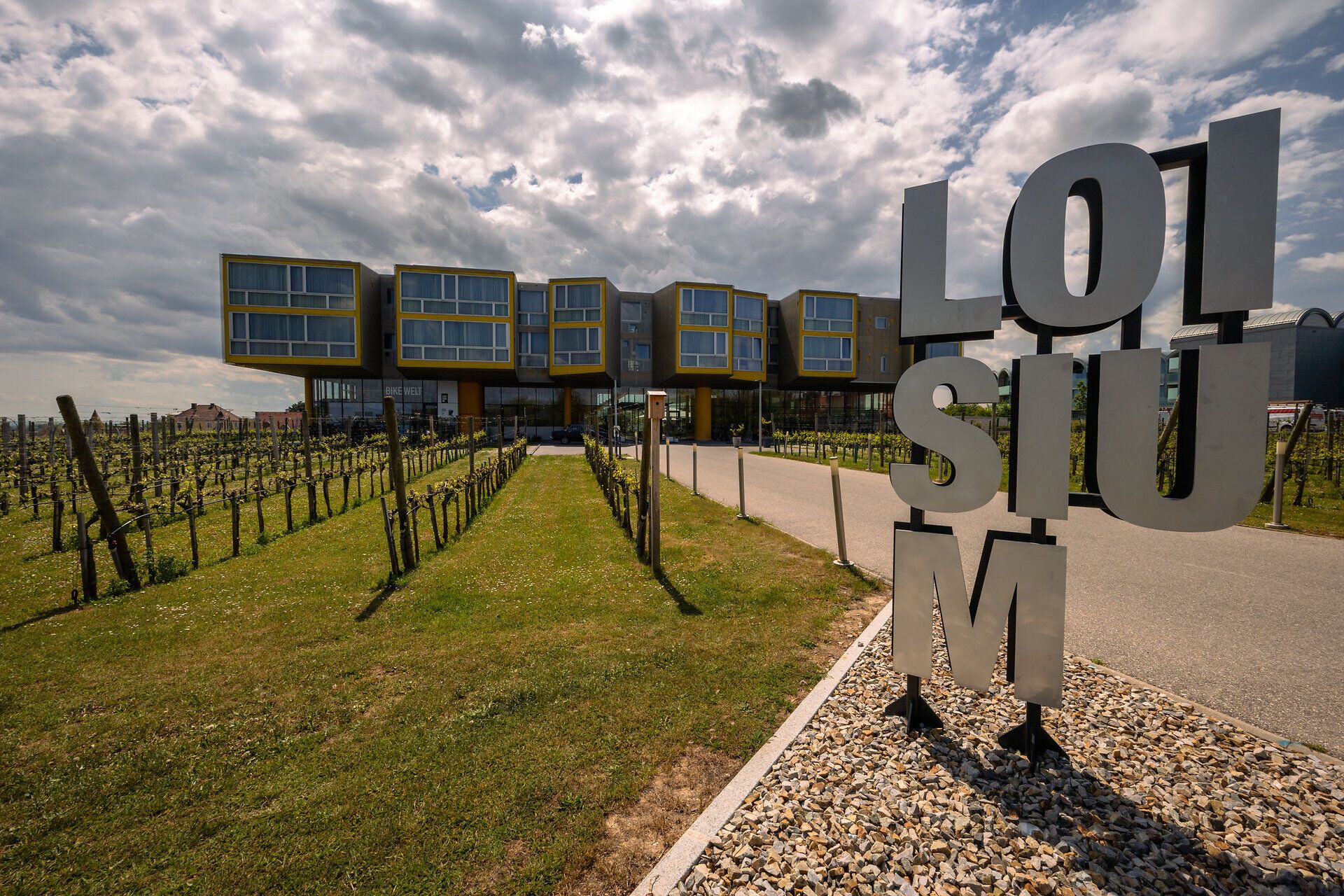 Umgeben von sanften Weinbergen und einer malerischen Landschaft lädt das LOISIUM Wine & Spa Hotel zu einem unvergesslichen Aufenthalt ein. Die moderne Architektur harmoniert perfekt mit der natürlichen Umgebung und schafft eine einladende Atmosphäre für Erholungssuchende und Weinliebhaber.