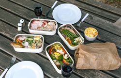Ein einladendes Picknick auf einem rustikalen Holztisch, umgeben von der üppigen Natur des Kamptals. Frische, bunte Speisen und erfrischende Getränke laden dazu ein, die warmen Sommertage in vollen Zügen zu genießen. Die Atmosphäre ist entspannt und harmonisch, perfekt für eine Auszeit im Freien.