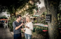 Eine Frau und ein Mann mit einem Weinglas in der Hand.