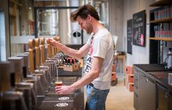 Mann an der Zapfsäule zapft Bier. 