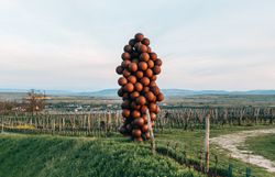 Eine beeindruckende Skulptur aus zahlreichen Weintrauben erhebt sich majestätisch über die sanften Hügel der Weinregion. Die harmonische Verbindung von Kunst und Natur lädt dazu ein, innezuhalten und die Schönheit der Umgebung zu genießen. Hier, wo die Weinreben in der Abendsonne leuchten, wird der Sommer in den Bergen zum unvergesslichen Erlebnis.