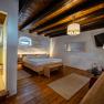 Gemütliches Zimmer mit Holzboden, Doppelbett, Dusche und moderner Einrichtung.