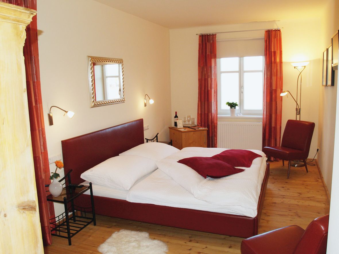 Gemütliches Schlafzimmer mit rotem Bett und Dekor.