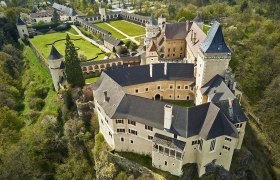 Luftaufnahme des Renaissanceschlosses Rosenburg mit umliegenden Gärten und Wäldern.