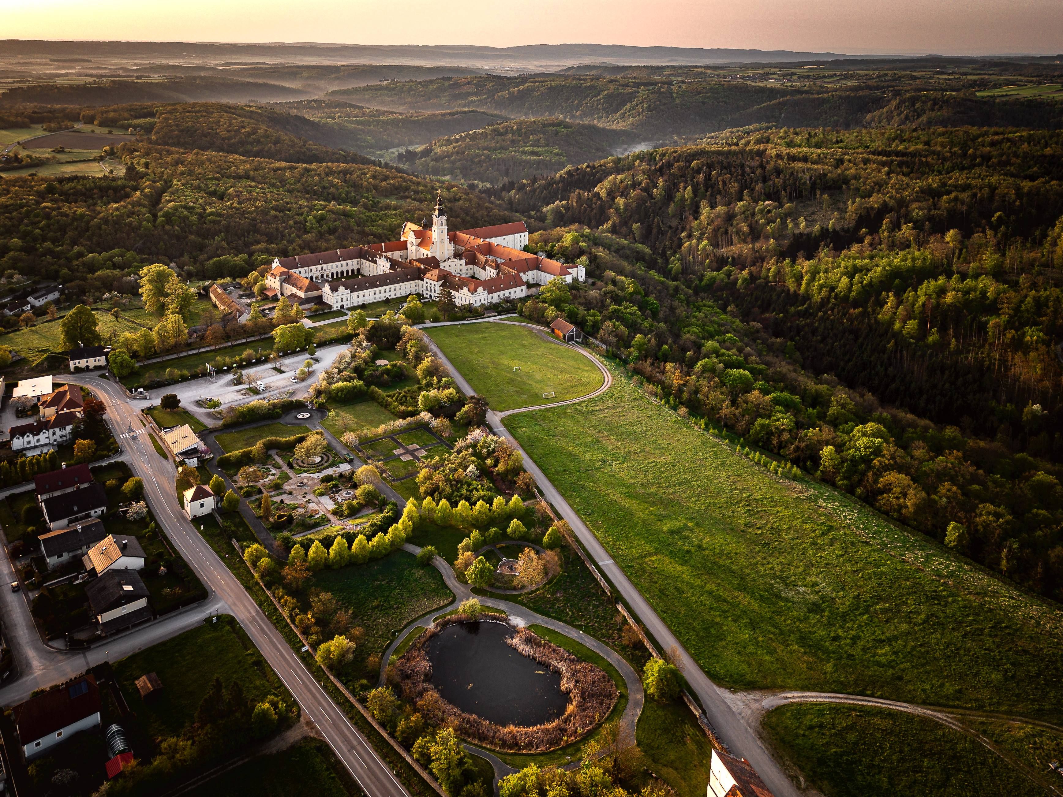 Luftaufnahme des Stifts Altenburg inmitten grüner Landschaft.