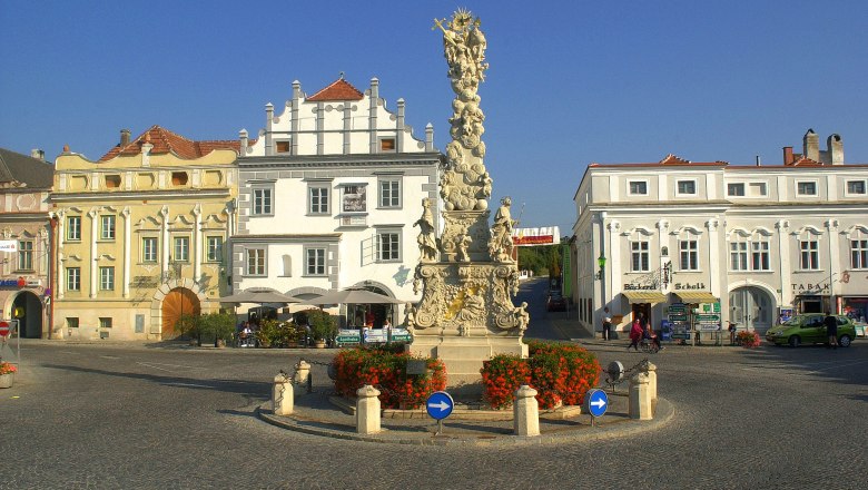 Historischer Platz in Langenlois mit barocker Säule und umliegenden Gebäuden.